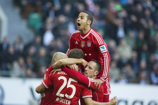 Bayern's Thiago Alcantara of Spain, top, Bayern's Arjen Robben of the Netherlands, Bayern's Thomas Mueller, and Bayern's Franck Ribery of France, bottom from left, celebrate after Mueller scored his side's 2nd goal during the German Bundesliga soccer match between VfL Wolfsburg and Bayern Munich in Wolfsburg, Germany, Saturday, March 8, 2014. (AP Photo/Gero Breloer) 