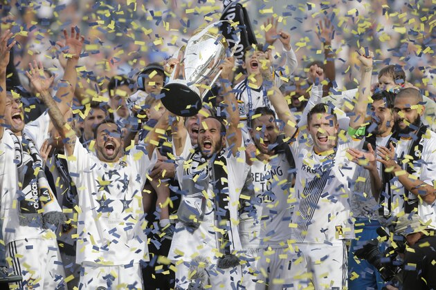 FILE - In this Dec. 7, 2014 file photo, Los Angeles Galaxy's Landon Donovan, center, hoists the trophy as he and teammates celebrate after winning the MLS Cup championship soccer match against the New England Revolution in Carson, Calif. The photo was part of a series of images by photographer Jae C. Hong which won the Thomas V. diLustro best portfolio award for 2014 given out by the Associated Press Sports Editors during their annual winter meeting in Orlando, Fla. (AP Photo/Jae C. Hong, File)