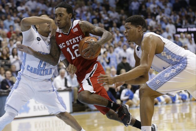North Carolina's Nate Britt (0) and Kennedy Meeks defend against North Carolina State's Anthony Barber (12) during the second half of an NCAA college basketball game in Chapel Hill, N.C., Tuesday, Feb. 24, 2015. North Carolina State won 58-46. (AP Photo/Gerry Broome)