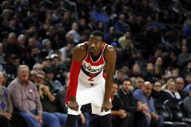 Washington Wizards guard John Wall looks to the scoreboard against the Detroit Pistons in the first half of an NBA basketball game in Auburn Hills, Mich., Sunday, Feb. 22, 2015. (AP Photo/Paul Sancya)