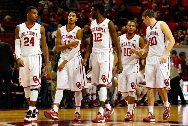 Jan 3, 2015; Norman, OK, USA; The Oklahoma Sooners players Buddy Hield (24) and Isaiah Cousins (11) and Khadeem Lattin (12) and Jordan Woodard (10) and Ryan Spangler (00) walk on the court after a timeout during the second half at Lloyd Noble Center. Oklahoma won 73-63. Mandatory Credit: Ray Carlin-USA TODAY Sports