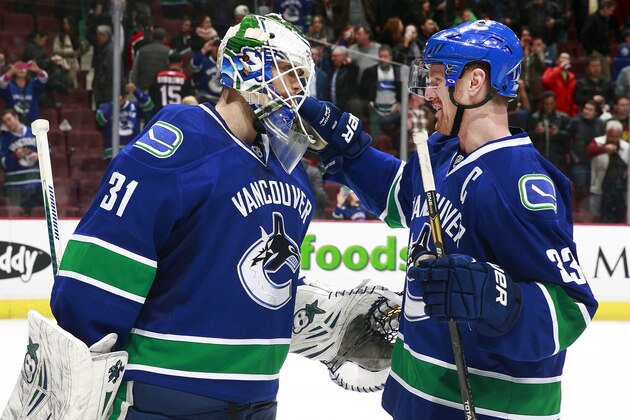 VANCOUVER, BC - MARCH 19: Eddie Lack #31 of the Vancouver Canucks is congratulated by teammate Henrik Sedin #33 during their NHL game against the Nashville Predators at Rogers Arena March 19, 2014 in Vancouver, British Columbia, Canada.  Vancouver won 2-0. (Photo by Jeff Vinnick/NHLI via Getty Images)