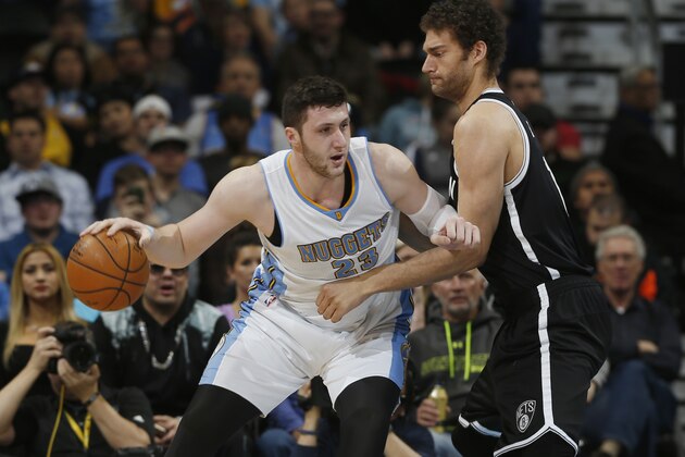 Denver Nuggets center Jusuf Nurkic, left, of Bosnia Herzegovina, works the ball inside for a shot as Brooklyn Nets center Brook Lopez defends in the first quarter of an NBA basketball game Monday, Feb. 23, 2015, in Denver. (AP Photo/David Zalubowski)
