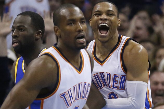 Oklahoma City Thunder guard Russell Westbrook, right, screams after a basket in the second quarter of an NBA basketball game against the Golden State Warriors in Oklahoma City, Friday, Jan. 16, 2015. At left are Warriors' Draymond Green and Thunder's Serge Ibaka (9). (AP Photo/Sue Ogrocki)
