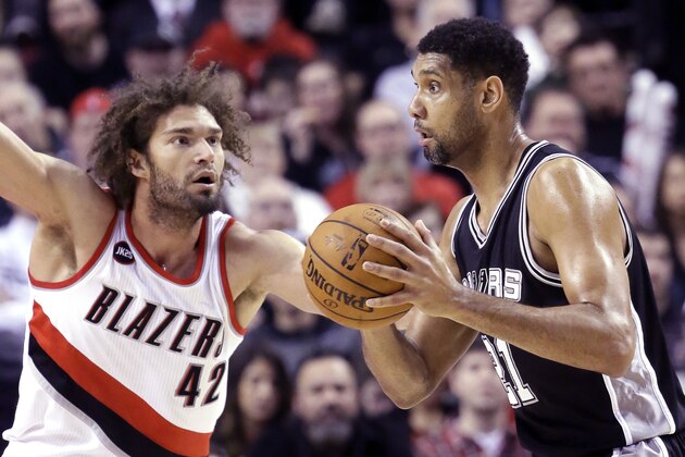 San Antonio Spurs forward Tim Duncan, right, looks to pass as Portland Trail Blazers center Robin Lopez defends during the first half of an NBA basketball game in Portland, Ore., Wednesday, Feb. 25, 2015. (AP Photo/Don Ryan)