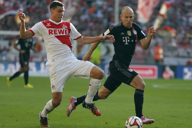 Cologne's Jonas Hector, left, and Bayern's Arjen Robben from the Netherlands challenge for the ball during the German first division Bundesliga soccer match between FC Cologne and Bayern Munich in Cologne, Germany, Saturday, Sept. 27, 2014. (AP Photo/Frank Augstein)