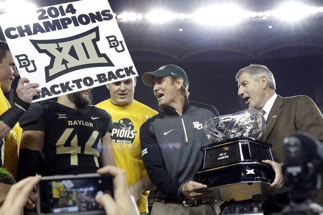 Big 12 Commissioner Bob Bowlsby, right, presents Baylor head coach Art Briles, center, with the conference trophy after their 38-27 win over Kansas State in an NCAA college football game, Saturday, Dec. 6, 2014, in Waco, Texas. (AP Photo/Tony Gutierrez)