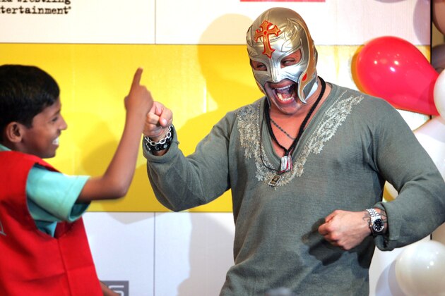 World Wrestling Entertainment star Rey Mysterio plays with a school boy in Mumbai, India, Tuesday, March 13, 2007. Ray urged children to study and become good human beings. (AP Photo/Rajesh Nirgude)