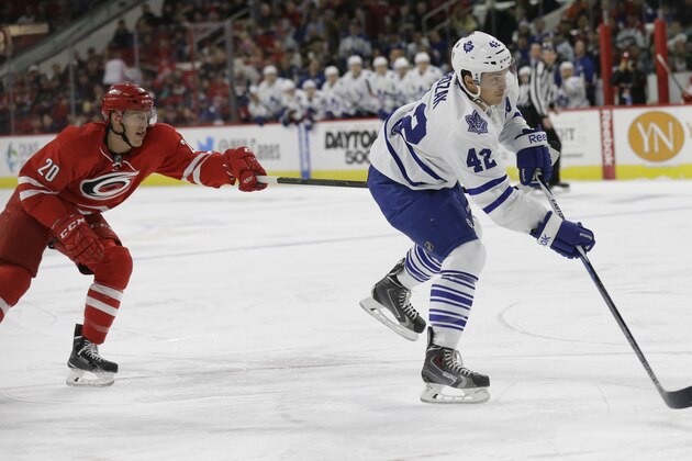 Toronto Maple Leafs' Tyler Bozak (42) shoots as Carolina Hurricanes' Riley Nash (20) defends during the first period of an NHL hockey game in Raleigh, N.C., Friday, Feb. 20, 2015. (AP Photo/Gerry Broome)