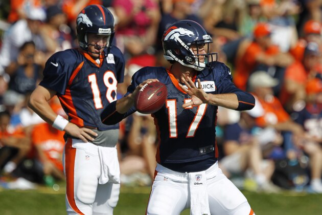 Denver Broncos quarterback Brock Osweiler, front, throws while Peyton Manning looks on during a morning session at the team's NFL training camp in Englewood, Colo., on Tuesday, Aug. 6, 2013. (AP Photo/David Zalubowski)