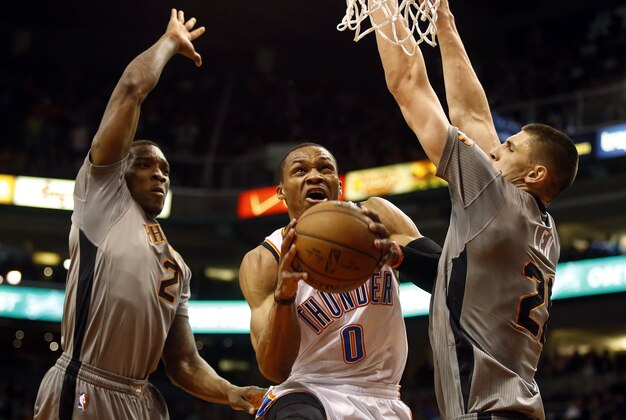 Feb 26, 2015; Phoenix, AZ, USA; Oklahoma City Thunder guard Russell Westbrook (0) shoots the ball between Phoenix Suns guard Eric Bledsoe (2) and center Alex Len (21) during the first quarter at US Airways Center. Mandatory Credit: Rick Scuteri-USA TODAY Sports