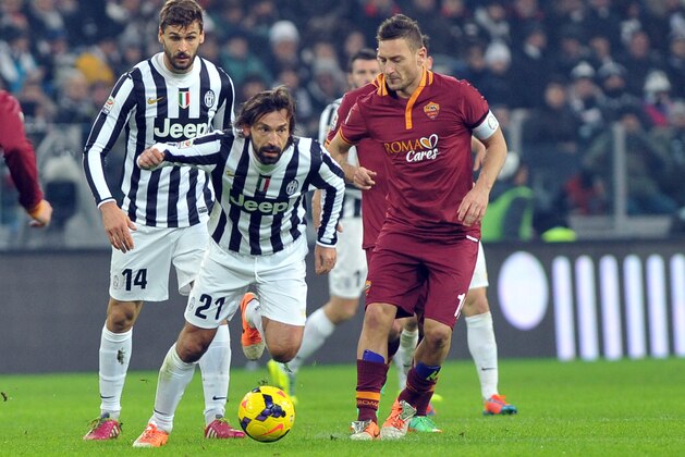 Juventus midfielder Andrea Pirlo, left, challenges the ball with AS Roma forward Francesco Totti during a Serie A soccer match between Juventus and AS Roma at the Juventus stadium, in Turin, Italy, Sunday, Jan. 5, 2014. (AP Photo/Massimo Pinca)