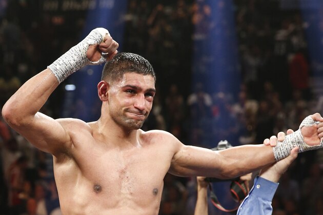 England's Amir Khan celebrates his unanimous decision over Luis Collazo in their silver welterweight title boxing fight Saturday, May 3, 2014, in Las Vegas. (AP Photo/Eric Jamison)