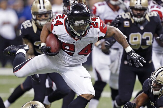 Atlanta Falcons running back Devonta Freeman (24) rushes for a touchdown past New Orleans Saints inside linebacker David Hawthorne (57) and defensive back Terrence Frederick in the second half of an NFL football game in New Orleans, Sunday, Dec. 21, 2014. (AP Photo/Rogelio Solis)