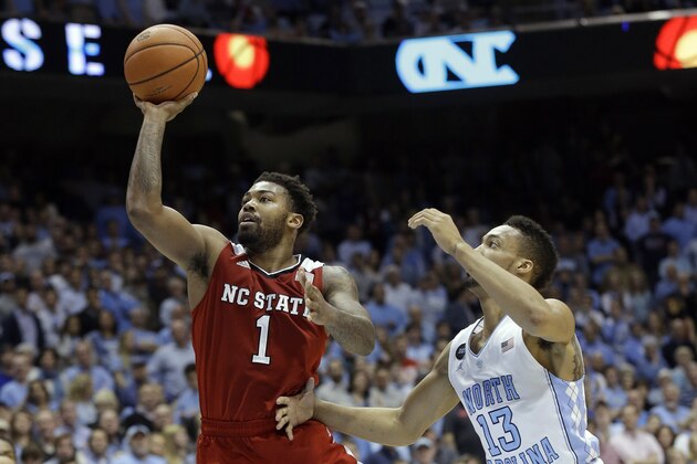 North Carolina State'sTrevor Lacey (1) shoots as North Carolina's J.P. Tokoto (13) defends during the second half of an NCAA college basketball game in Chapel Hill, N.C., Tuesday, Feb. 24, 2015. North Carolina State won 58-46. (AP Photo/Gerry Broome)