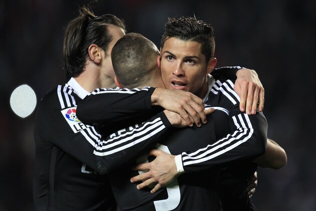 Real Madrid's Karim Benzema, from France is congratulated by teammate Cristiano Ronaldo, from Portugal and Gareth Bale, from Wales after Benzema scoring a goal against Elche during a Spanish La Liga soccer match at the Manuel Martinez Valero stadium in Elche, Spain, on Sunday, Feb. 22, 2015.(AP Photo/Alberto Saiz)