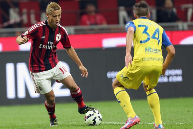 MILAN, ITALY - OCTOBER 04:  Keissuke Honda (L) of Milan is challenged by Cristiano Biraghi of Chievo during the Serie A match between AC Milan and AC Chievo Verona at Stadio Giuseppe Meazza on October 4, 2014 in Milan, Italy.  (Photo by Maurizio Lagana/Getty Images)
