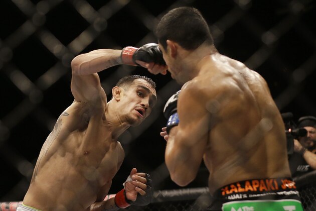 Tony Ferguson, left, punches Danny Castillo during the second round of a lightweight mixed martial arts bout at UFC 177 in Sacramento, Calif., Saturday, Aug. 30, 2014. Ferguson won by split decision. (AP Photo/Jeff Chiu)