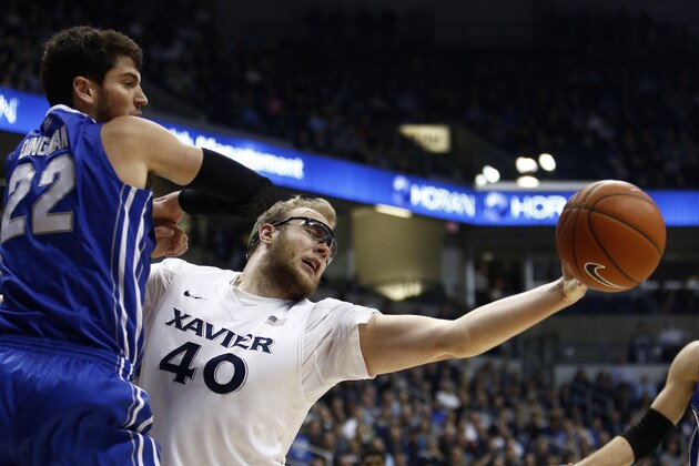 Xavier center Matt Stainbrook (40) reaches for the ball against Creighton guard Avery Dingman (22) in the first half of an NCAA college basketball game, Wednesday, Feb. 4, 2015, in Cincinnati. (AP Photo/David Kohl)