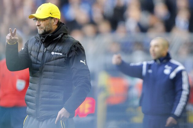 Dortmund's head coach Juergen Klopp, left, and Schalke's head coach Roberto di Matteo from Italy gesture  during the German first division Bundesliga soccer match between BvB Borussia Dortmund  and Schalke 04 in Dortmund, Germany, Saturday, Feb. 28, 2015.  Reflection caused by persons on the pitch.  (AP Photo/Frank Augstein)