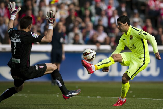 Barcelona's Luis Suarez, right, in action with Granada's goalkeeper Oier Olazabal, left, during a Spanish La Liga soccer match between Granada and FC Barcelona at Los Carmenes stadium in Granada, Spain, Saturday Feb. 28, 2015. (AP Photo/Daniel Tejedor)