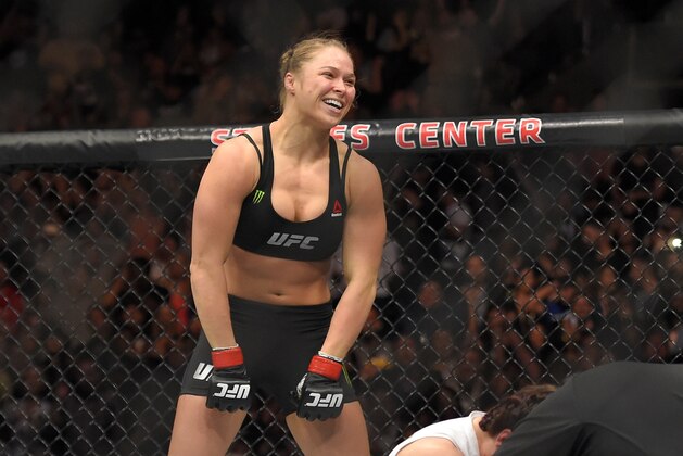 Ronda Rousey, top, celebrates as Cat Zingano kneels on the mat during a UFC 184 mixed martial arts bantamweight title bout, Saturday, Feb. 28, 2015, in Los Angeles. Rousey won after Zingano tapped out 14 seconds into the bout. (AP Photo/Mark J. Terrill)
