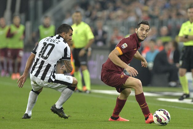 Roma' Kostantinos Manolas, right, controls the ball next to Juventus' Carlos Tevez during a Serie A soccer match between Juventus and Roma at the Juventus stadium, in Turin, Italy, Sunday, Oct. 5, 2014. (AP Photo/Massimo Pinca)
