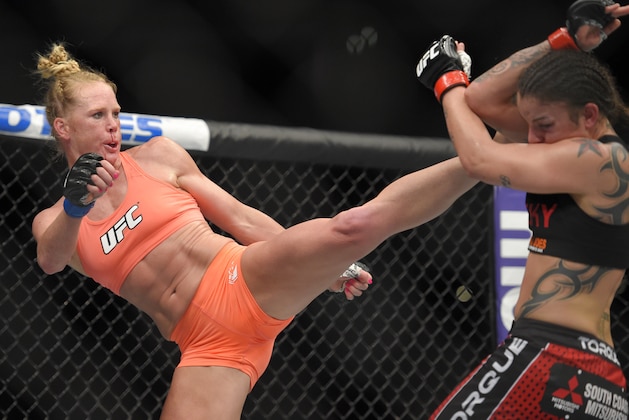 Holly Holm, left, connects with Raquel Pennington during a UFC 184 mixed martial arts bantamweight bout, Saturday, Feb. 28, 2015, in Los Angeles. Holm won by a split decision. (AP Photo/Mark J. Terrill)