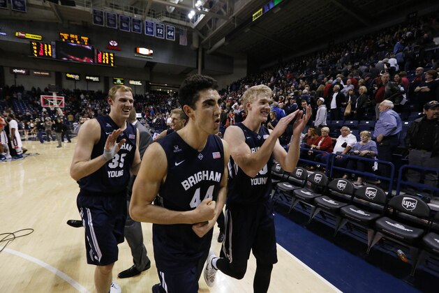 BYU's Isaac Neilson (35), Corbin Kaufusi (44) and Ryan Andrus celebrate after winning an NCAA college basketball game against Gonzaga, Saturday, Feb. 28, 2015, in Spokane, Wash. (AP Photo/Young Kwak)