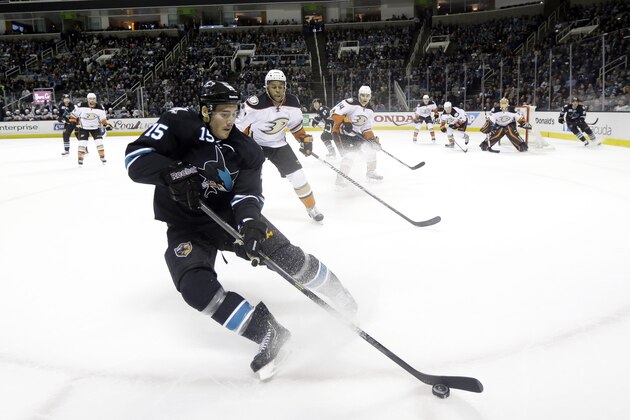San Jose Sharks' James Sheppard (15) controls the puck against the boards in front of Anaheim Ducks' Devante Smith-Pelly (12) during the first period of an NHL hockey game Thursday, Jan. 29, 2015, in San Jose, Calif. (AP Photo/Marcio Jose Sanchez)