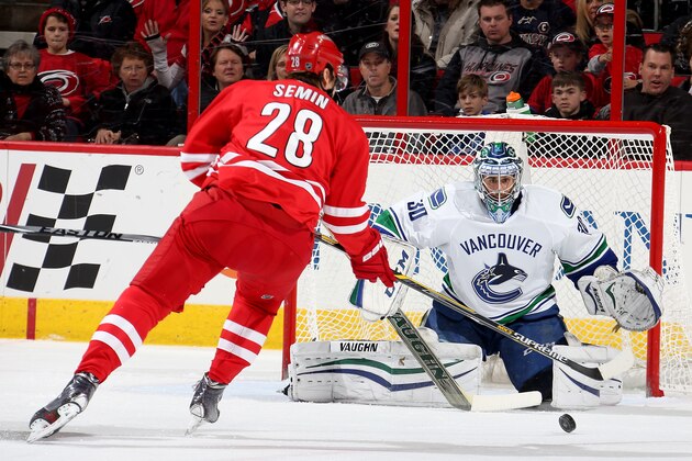 RALEIGH, NC - JANUARY 16: Ryan Miller #30 of the Vancouver Canucks defends the net from Alexander Semin #28 of the Carolina Hurricanes during their NHL game at PNC Arena on January 16, 2015 in Raleigh, North Carolina.  (Photo by Gregg Forwerck/NHLI via Getty Images)