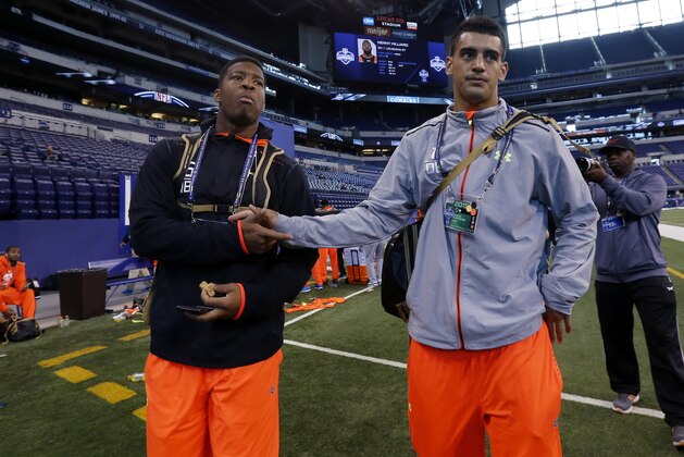 Florida State quarterback Jameis Winston, left, walks with Oregon quarterback Marcus Mariota after participating at the NFL football scouting combine in Indianapolis, Saturday, Feb. 21, 2015. (AP Photo/Julio Cortez)