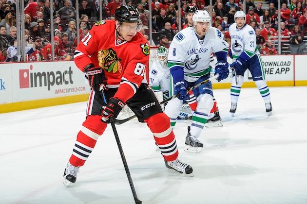 CHICAGO, IL - FEBRUARY 11:  Marian Hossa #81 of the Chicago Blackhawks grabs the puck as Chris Tanev #8 of the Vancouver Canucks skates behind during the NHL game at the United Center on February 11, 2015 in Chicago, Illinois.  (Photo by Bill Smith/NHLI via Getty Images)