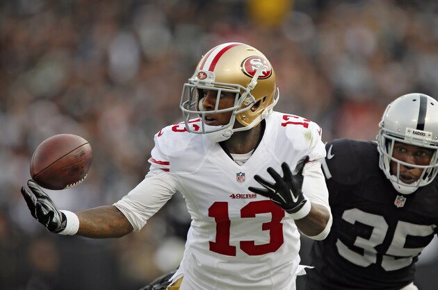 OAKLAND, CA - DECEMBER 7:  Wide receiver Stevie Johnson #13 of the San Francisco 49ers tries unsuccessfully to pull down a pass against cornerback Chimdi Chekwa #35 of the Oakland Raiders in the second quarter on December 7, 2014 at O.co Coliseum in Oakland, California.  The Raiders won 24-13.  (Photo by Brian Bahr/Getty Images)
