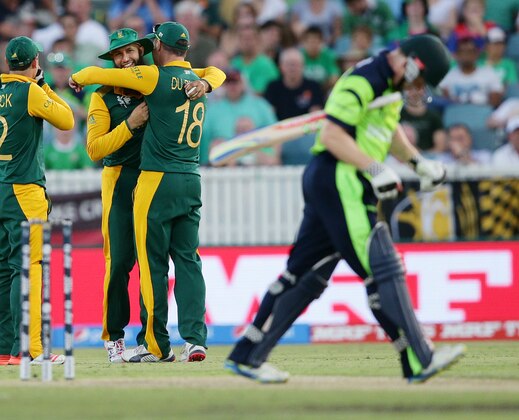 South Africa's Hashim Amla, centre, is congratulated by teammates Quinton De Kock and Francois Du Plessis, right, after taking a catch to dismiss Ireland's Niall O'Brien, right, during their Cricket World Cup Pool B match in Canberra, Australia, Tuesday, March 3, 2015. (AP Photo/Rob Griffith)
