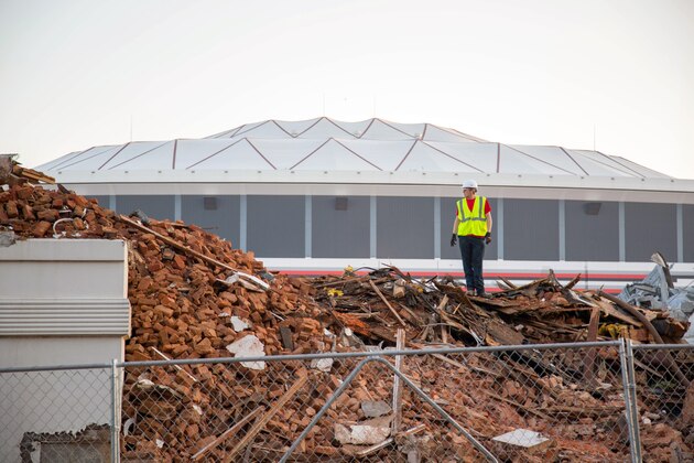A construction worker stands atop rubble after the of Friendship Baptist Church was demolished, Tuesday, July 29, 2014 in Atlanta. In the background is the Georgia Dome. The church was demolished to make room for the Atlanta Falcons NFL football teams new stadium, scheduled to open in 2017. (AP Photo/Kevin Liles)