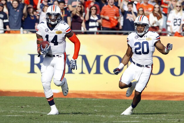 Jan 1, 2015; Tampa, FL, USA; Auburn Tigers quarterback Nick Marshall (14) runs the ball along side running back Corey Grant (20) during the game against the Wisconsin Badgers in the 2015 Outback Bowl at Raymond James Stadium. The Wisconsin Badgers defeated the Auburn Tigers in overtime 34-31. Mandatory Credit: Mark Zerof-USA TODAY Sports