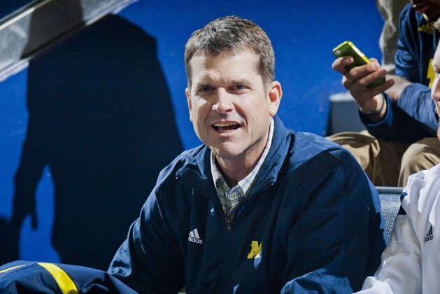 Michigan football head coach Jim Harbaugh attends an NCAA college basketball game against Northwestern at Crisler Center in Ann Arbor, Mich., Saturday, Jan. 17, 2015. (AP Photo/Tony Ding)