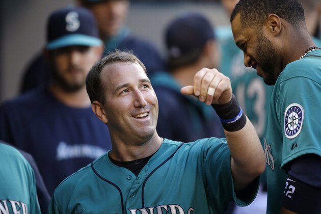 Seattle Mariners' Willie Bloomquist smiles in the dugout as he is congratulated after scoring against the New York Mets in the third inning of a baseball game Monday, July 21, 2014, in Seattle. (AP Photo/Elaine Thompson)