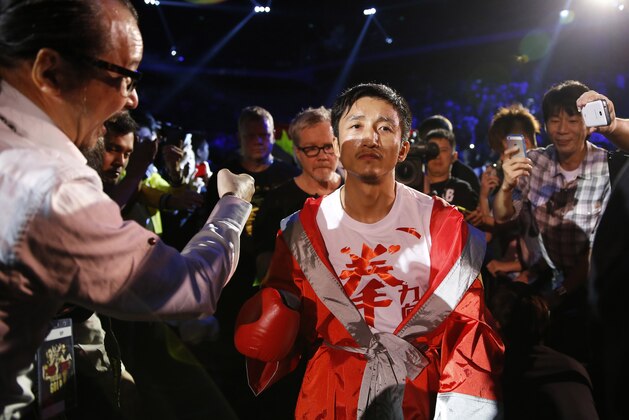 In this  July 27, 2013 photo, Chinese boxer Zou Shiming, center, is greeted by his fans before the Flyweight Bout match against Mexico's Jesus Ortega at the Cotai Arena in Venetian Macao in Macau. The Chinese fighter’s victory at a Macau showdown brings the world’s top casino market a step closer to challenging Las Vegas for dominance of another Sin City staple: big-time boxing matches. Macau, which long ago eclipsed Vegas as the world's top gambling city, is now looking to add to its allure by holding the kind of boxing bouts that Las Vegas is known for. (AP Photo/Dennis Ho)