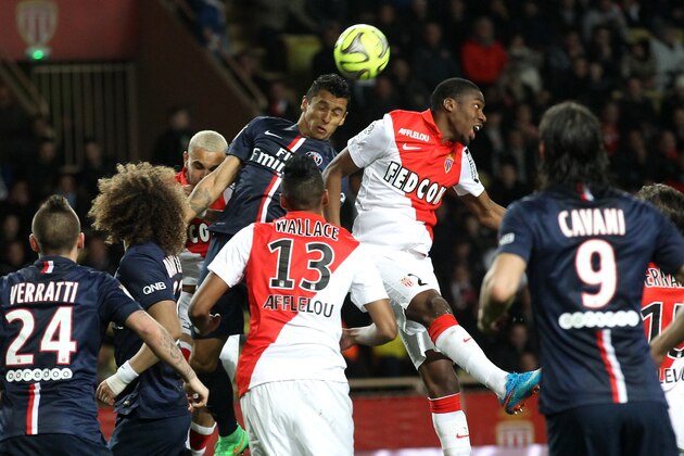 PSG's Marquinhos, center left, jumps for the ball with Monaco's Geoffrey Kondogbia, center right, during the French League One soccer match between Monaco and Paris Saint Germain, in Monaco stadium, Sunday, March 1, 2015. (AP Photo/Lionel Cironneau)