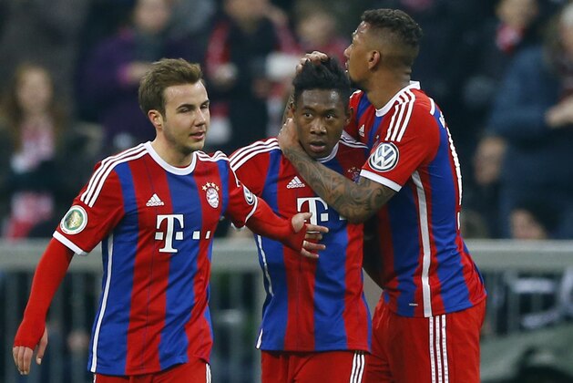 Bayern's David Alaba, center, celebrates with teammates Mario Goetze, left, and Jerome Boateng after scoring his side's opening goal during the German Soccer Cup round of sixteen match between FC Bayern Munich and Eintracht Braunschweig in Munich, southern Germany, Wednesday, March 4, 2015. (AP Photo/Matthias Schrader)