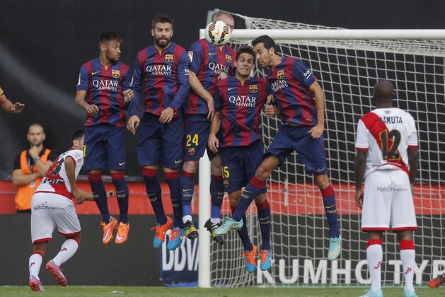10ThingstoSeeSports - Barcelona's players try to stop the ball after a free kick during a Spanish La Liga soccer match between Rayo Vallecano and FC Barcelona at the Vallecas stadium in Madrid, Spain, Saturday, Oct. 4, 2014. (AP Photo/Andres Kudacki, File)