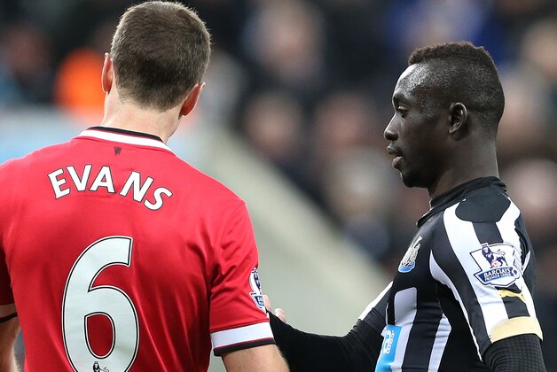 Newcastle United's Papiss Cisse, right, has words with Manchester United's Jonny Evans, left, during their English Premier League soccer match between Newcastle United and Manchester United at St James' Park, Newcastle, England, Wednesday, March, 4, 2015. (AP Photo/Scott Heppell)
