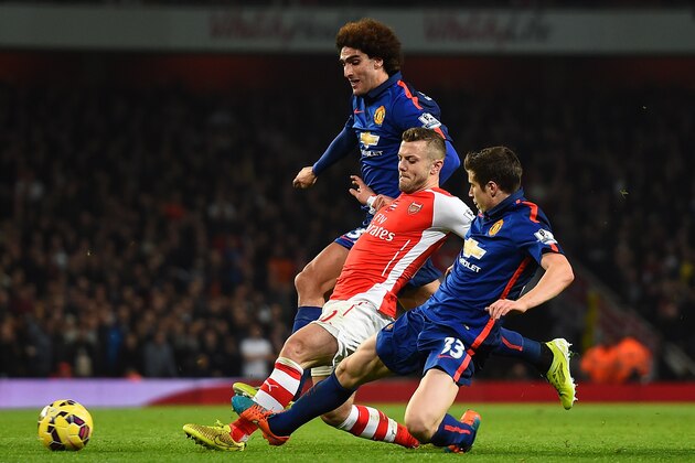 LONDON, ENGLAND - NOVEMBER 22: Jack Wilshere of Arsenal is tackled by Marouane Fellaini of Manchester United (L) and Paddy McNair of Manchester United during the Barclays Premier League match between Arsenal and Manchester United at Emirates Stadium on November 22, 2014 in London, England. (Photo by Shaun Botterill/Getty Images)