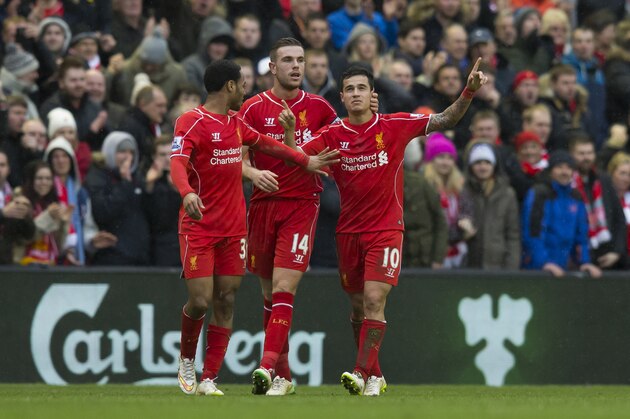 Liverpool's Philippe Coutinho, right, celebrates with teammates Jordan Henderson, centre, and Raheem Sterling after scoring against Manchester City's during the English Premier League soccer match between Liverpool and Manchester City at Anfield Stadium, Liverpool, England, Sunday, March 1, 2015. Liverpool won the match 2-1. (AP Photo/Jon Super)