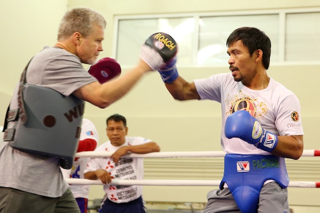 MACAU - NOVEMBER 21:  Manny Pacquiao works the mitts with trainer Freddie Roach during a workout session at The Venetianon November 21, 2014 in Macau, Macau.  (Photo by Chris Hyde/Getty Images)
