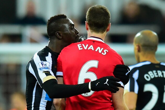 NEWCASTLE UPON TYNE, ENGLAND - MARCH 04:  Manchester United player Jonny Evans (r) looks on as Papiss Cisse of Newcastle appears to spit during the Barclays Premier League match between Newcastle United and Manchester United at St James' Park on March 4, 2015 in Newcastle upon Tyne, England.  (Photo by Stu Forster/Getty Images)