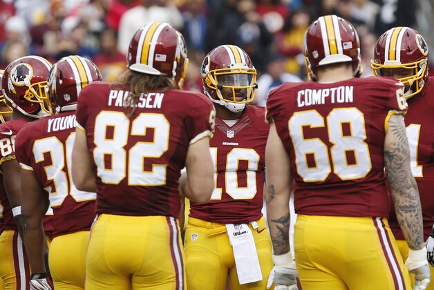 Dec 28, 2014; Landover, MD, USA; Washington Redskins quarterback Robert Griffin III (10) huddles with teammates during a timeout against the Dallas Cowboys in the first quarter at FedEx Field. Mandatory Credit: Geoff Burke-USA TODAY Sports
