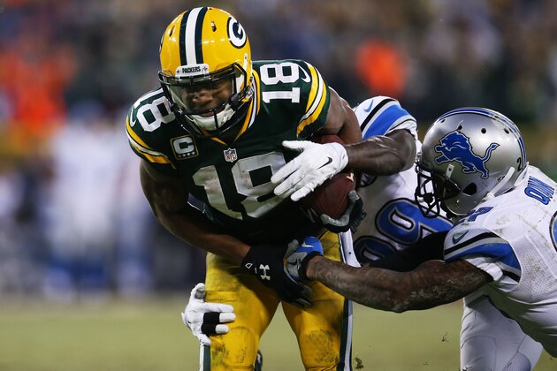 GREEN BAY, WI - DECEMBER 28:  Randall Cobb #18 of the Green Bay Packers runs for a first down against the defense of  Cassius Vaughn #29 and  Glover Quin #27  of the Detroit Lions in the second quarter at Lambeau Field on December 28, 2014 in Green Bay, Wisconsin.  (Photo by Chris Graythen/Getty Images)